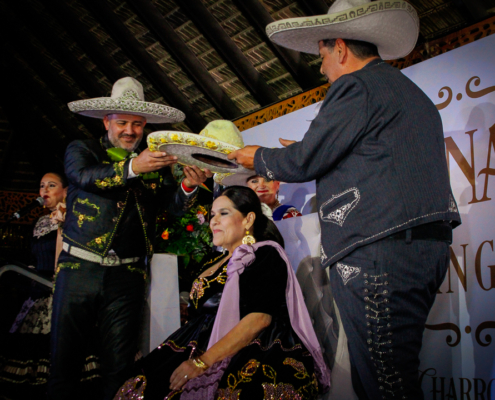 El presidente, José Antonio Salcedo, y el tesorero de Federación, Rafael Alberto Rodríguez, coronan a la reina de charros mayores, Rosa Angélica I