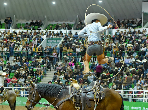 Ramiro Márquez de Rancho El Diamante "A" ejecutando su pasada sobre el caballo para emocionar al respetable